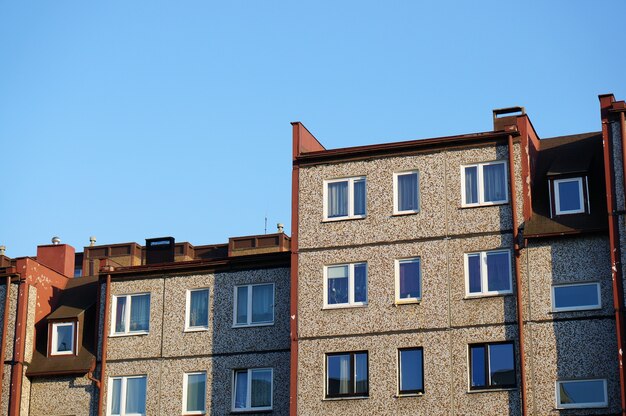 Facade of a row of apartment buildings against a clear blue sky