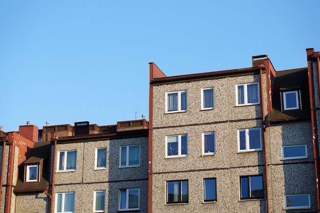 Facade of a row of apartment buildings against a clear blue sky