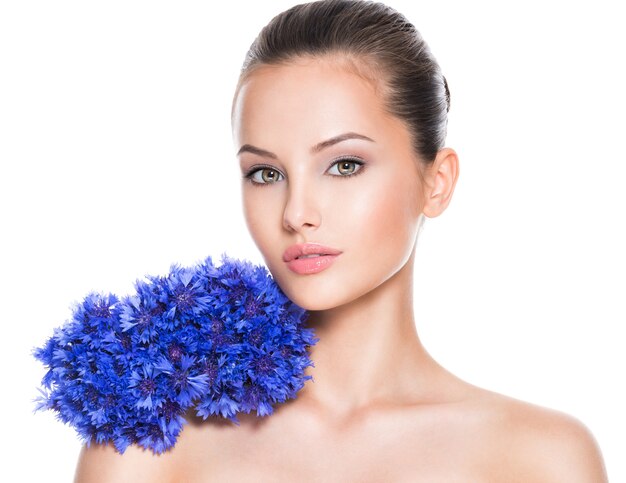Лицо красивой девушки с голубыми букетовыми полевыми цветами