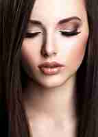 Foto gratuita volto di bella giovane donna con trucco marrone e capelli lisci