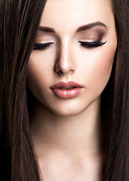 Бесплатное фото Лицо красивой молодой женщины с коричневым макияжем и прямыми волосами