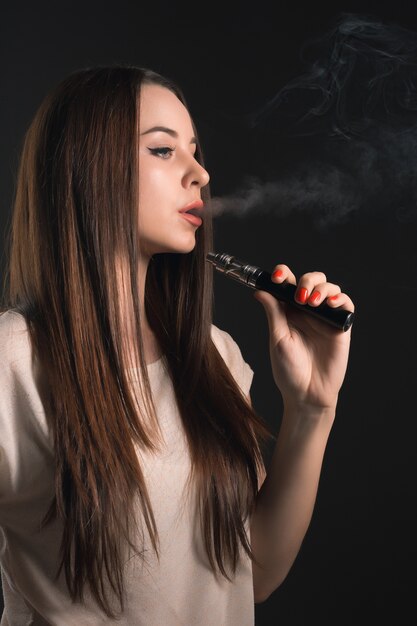 ブラックスタジオでvaping若い女性の顔