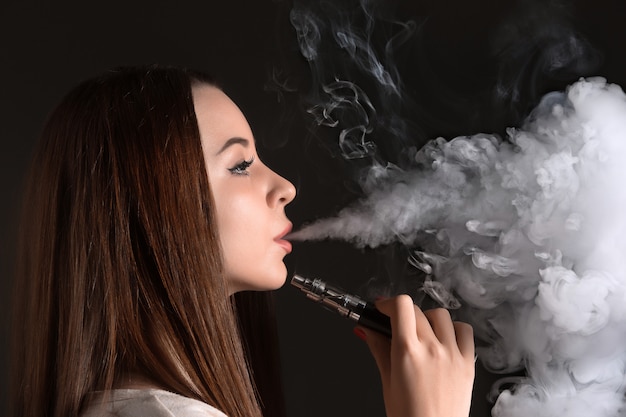 face of vaping young woman on black