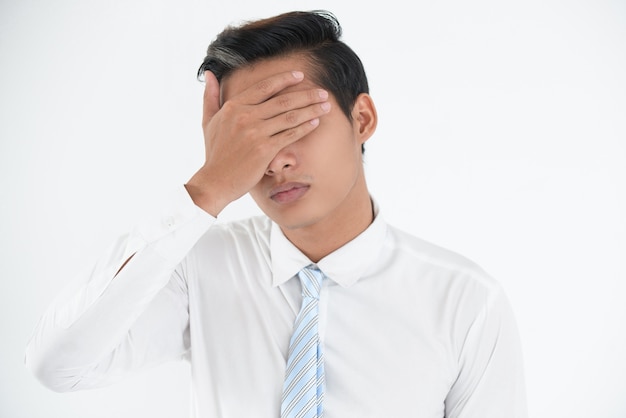 Face of worried young businessman making mistake