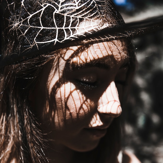 Free photo face of young woman in witch hat closing eyes