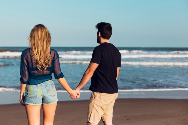 Faceless couple looking at sea