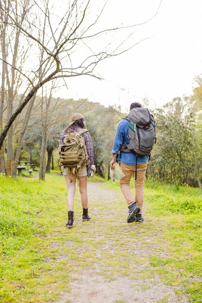 Faceless couple with backpacks