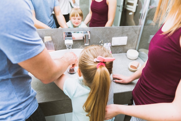 Faceless family washing hands