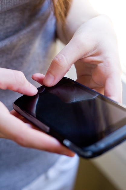 Faceless female using smartphone