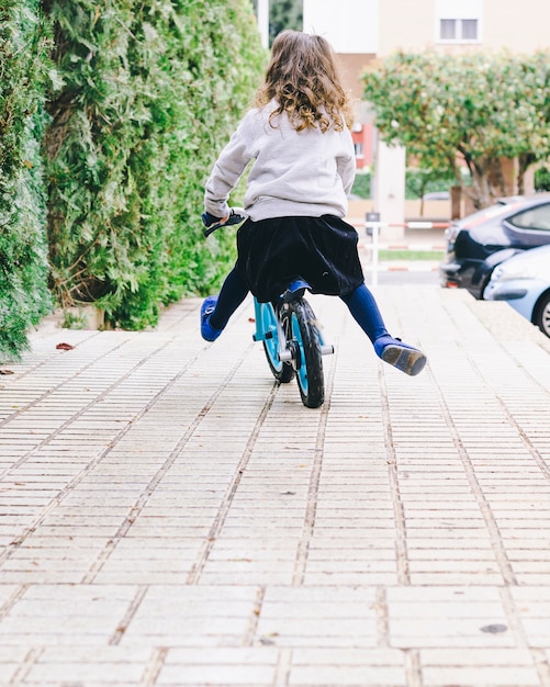 Faceless girl riding bicycle