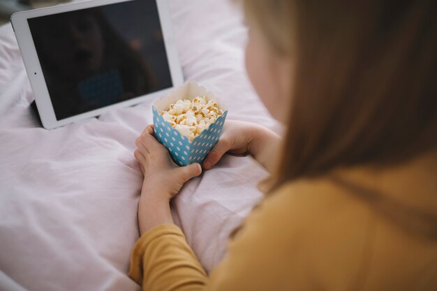 Faceless girl watching film on tablet