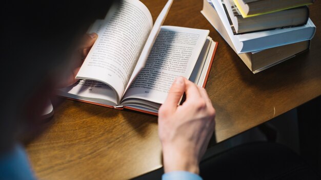 Faceless man flipping pages of book