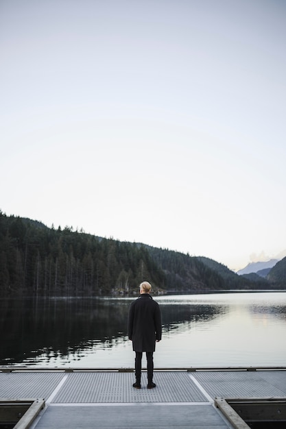 Faceless man looking at water