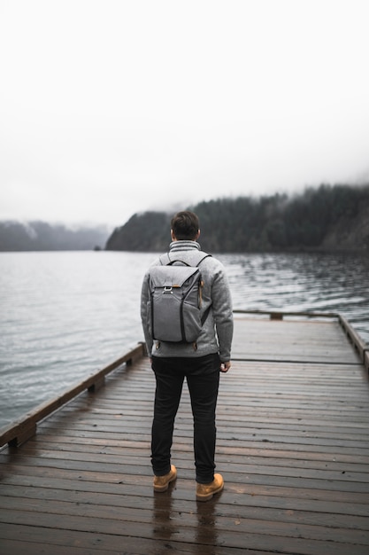 Faceless man standing on pier