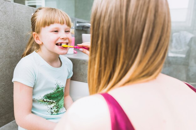 Безликая мать чистит зубы дочери