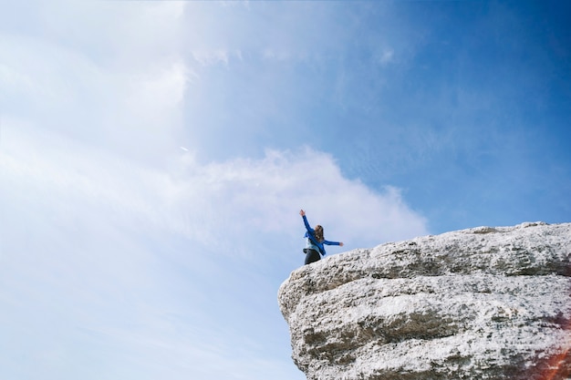 Faceless woman on cliff