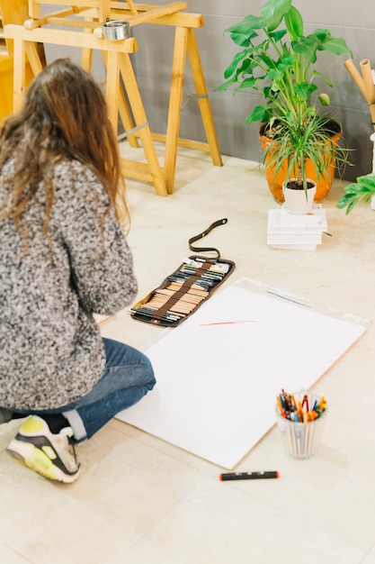 Faceless woman drawing on floor