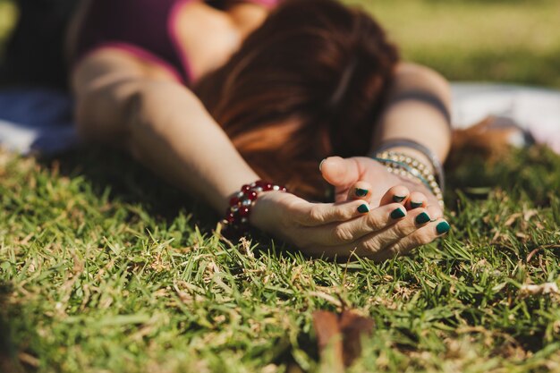 草の上に横たわっている顔のない女性