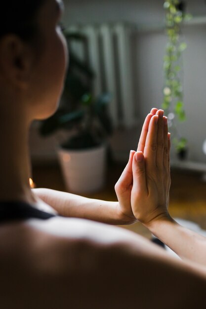 Faceless woman meditating at home