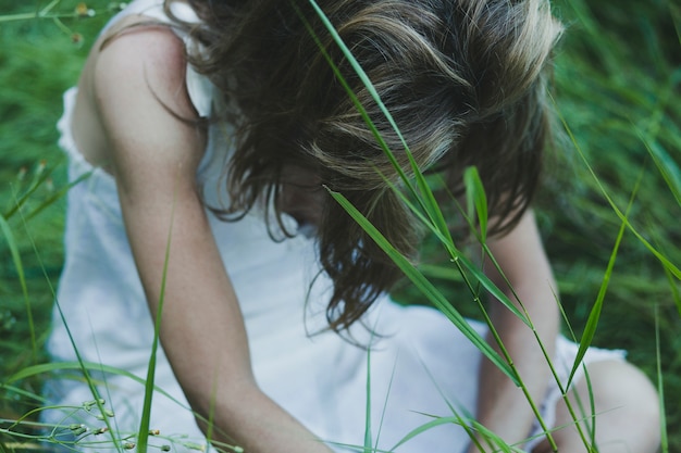 Free photo faceless woman sitting in field