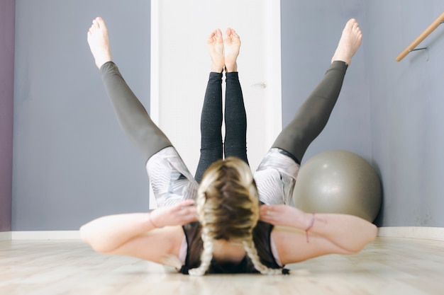 Free photo faceless women exercising on floor