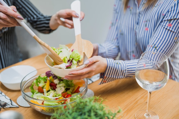 Free photo faceless women taking salad