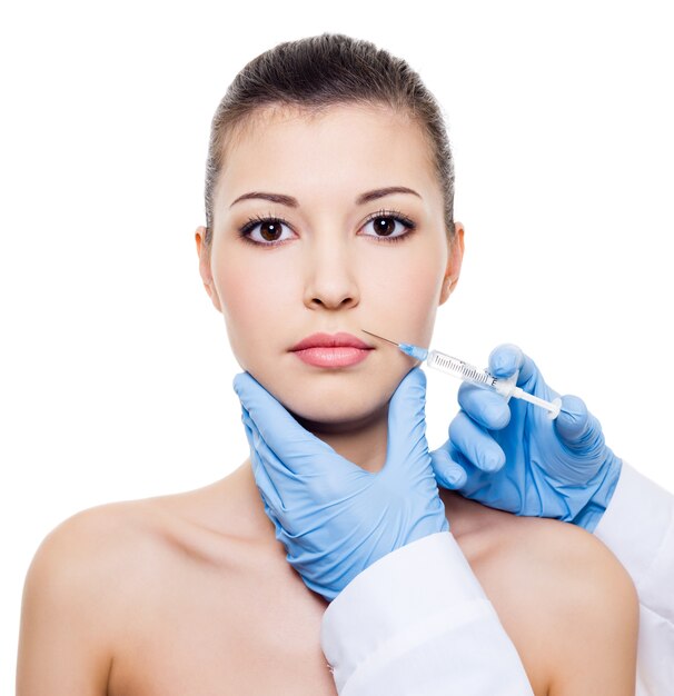 Facial care.  Injection of botox in beautiful woman's face  isolated white