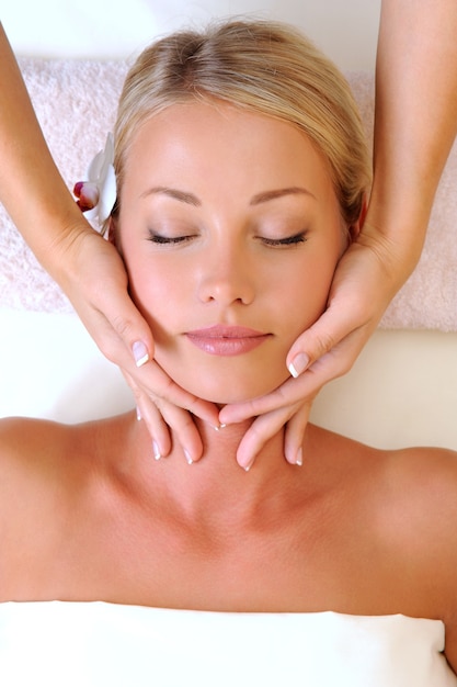 Foto gratuita massaggio facciale per bella giovane donna nel salone di bellezza