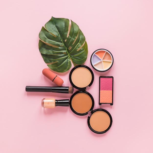 Facial powders with nail polish and leaf on table