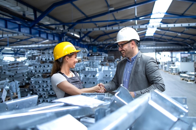 Factory manager visiting production line and congratulating worker for hard work and good results