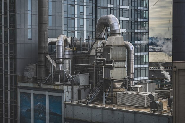 Free photo factory surrounded by high-rise buildings with greenery