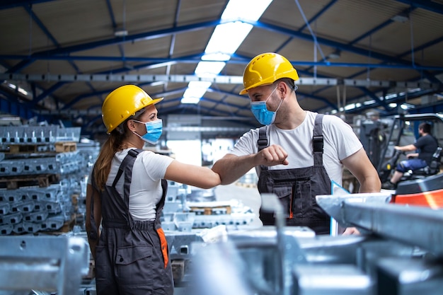 Factory workers greeting each others with elbows during corona virus pandemic