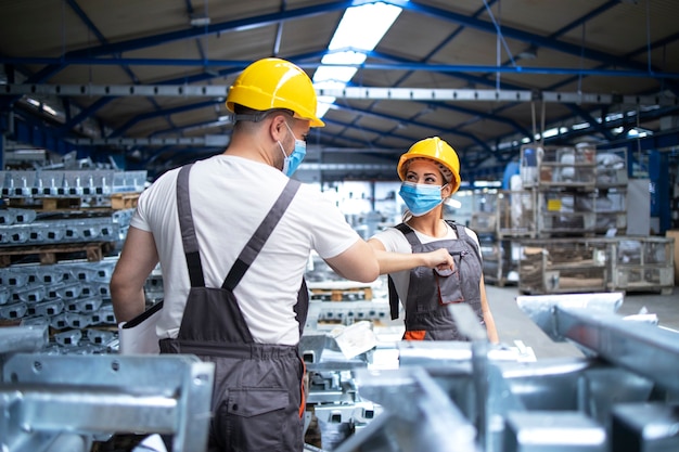 Free photo factory workers greeting each others with elbows during corona virus pandemic