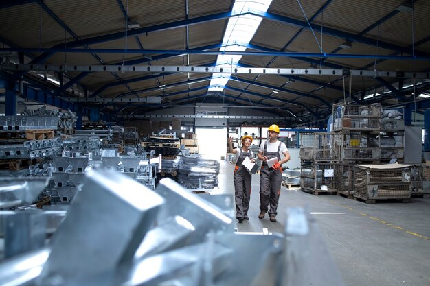 Factory workers in industrial production hall