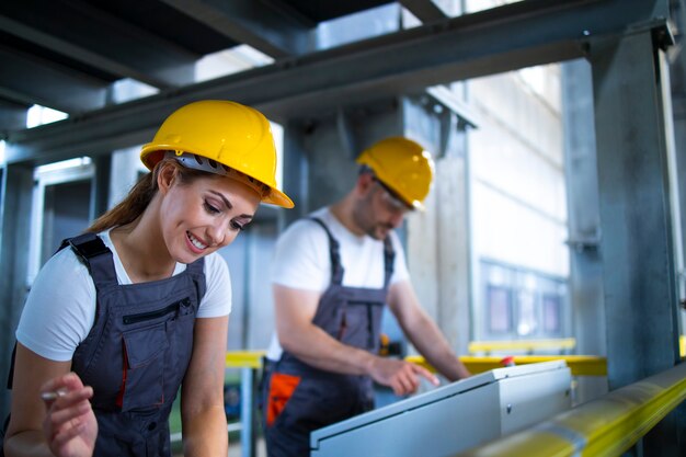 Factory workers monitoring industrial machines and production remotely in control room