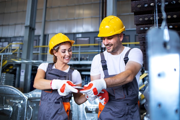 Factory workers working together in industrial metal production line