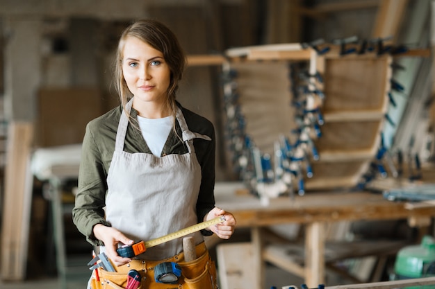 Fair-haired woodworker with tape measure