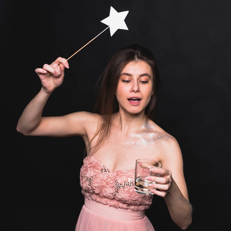 Free Photo fairy woman waving magic wand above glass 