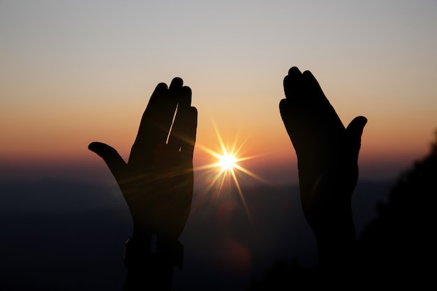 Faith of christian concept: spiritual prayer hands over sun shine