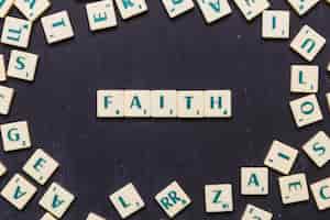 Free photo faith scrabble letters over black background