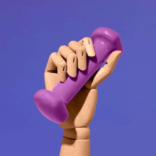 Free photo fake hand holding dumbbell still life