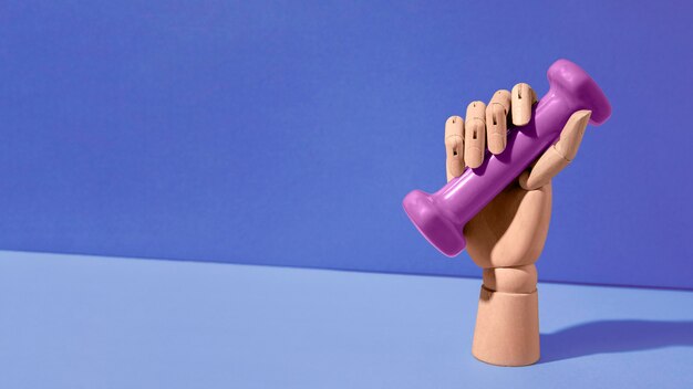 fake hand holding purple dumbbell
