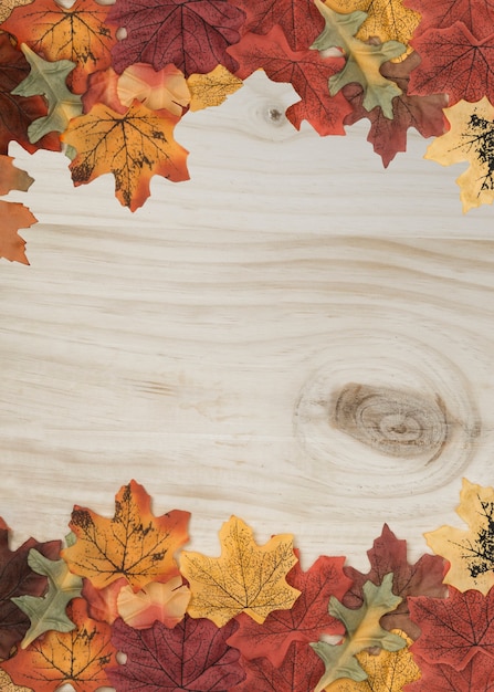 Free photo fall leaves side frame on wooden surface