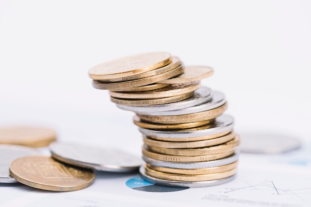 Fallen stack of coins on white background over the graph