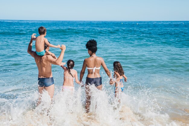 Familia running into the blue water