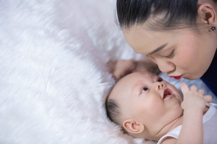 無料Photo 家族、両親、赤ちゃんは、リビングルームのベッドに横になります。