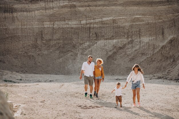 Family alltogether having fun in a sandy quarry