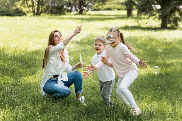 Семья дует пузыри в парке