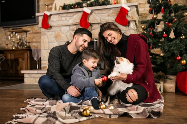 Foto gratuita la famiglia vicino al camino a natale