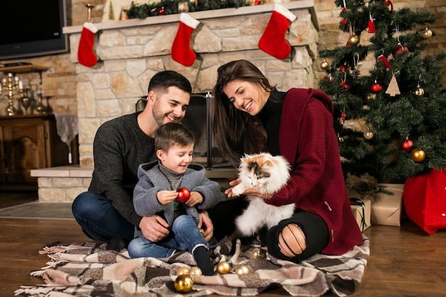 Foto gratuita la famiglia vicino al camino a natale